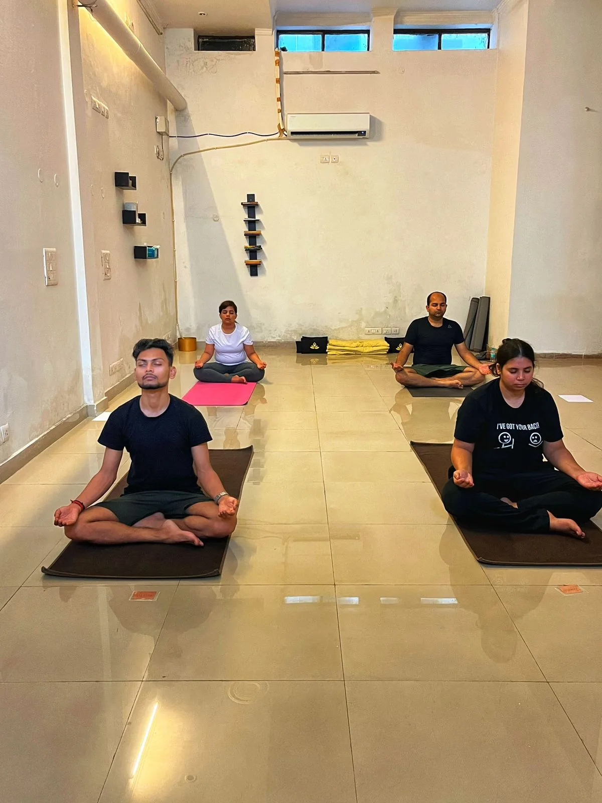 Practitioners seated in silent meditation on mats at Dhyana Yogasthala Sonepat studio